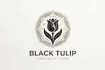 Elegant hospitality logo for Black Tulip LLC featuring a stylized black tulip flower centered within a gold and black intricate circular mandala, set against a light textured background.